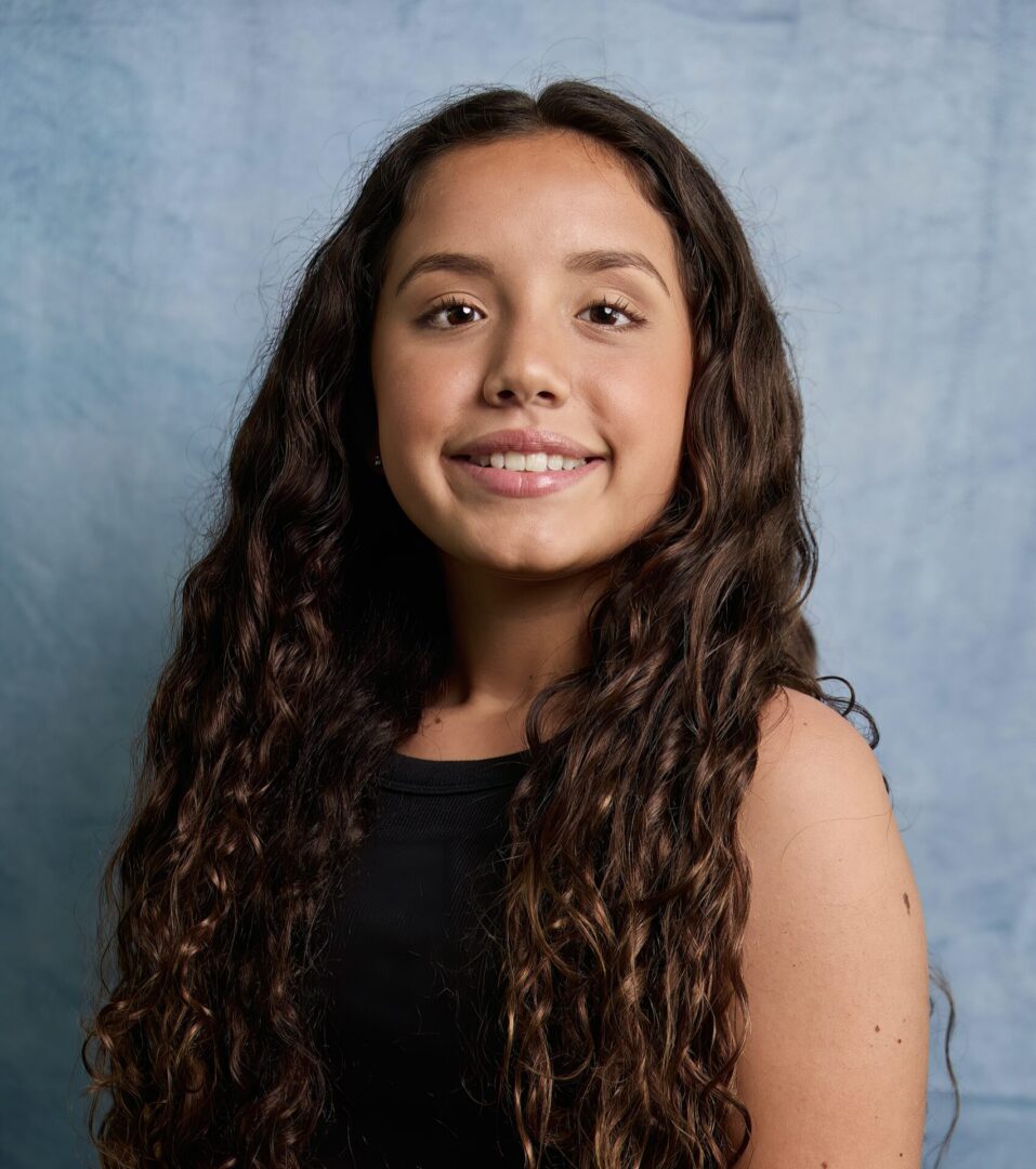 A young girl with long hair and a black top.