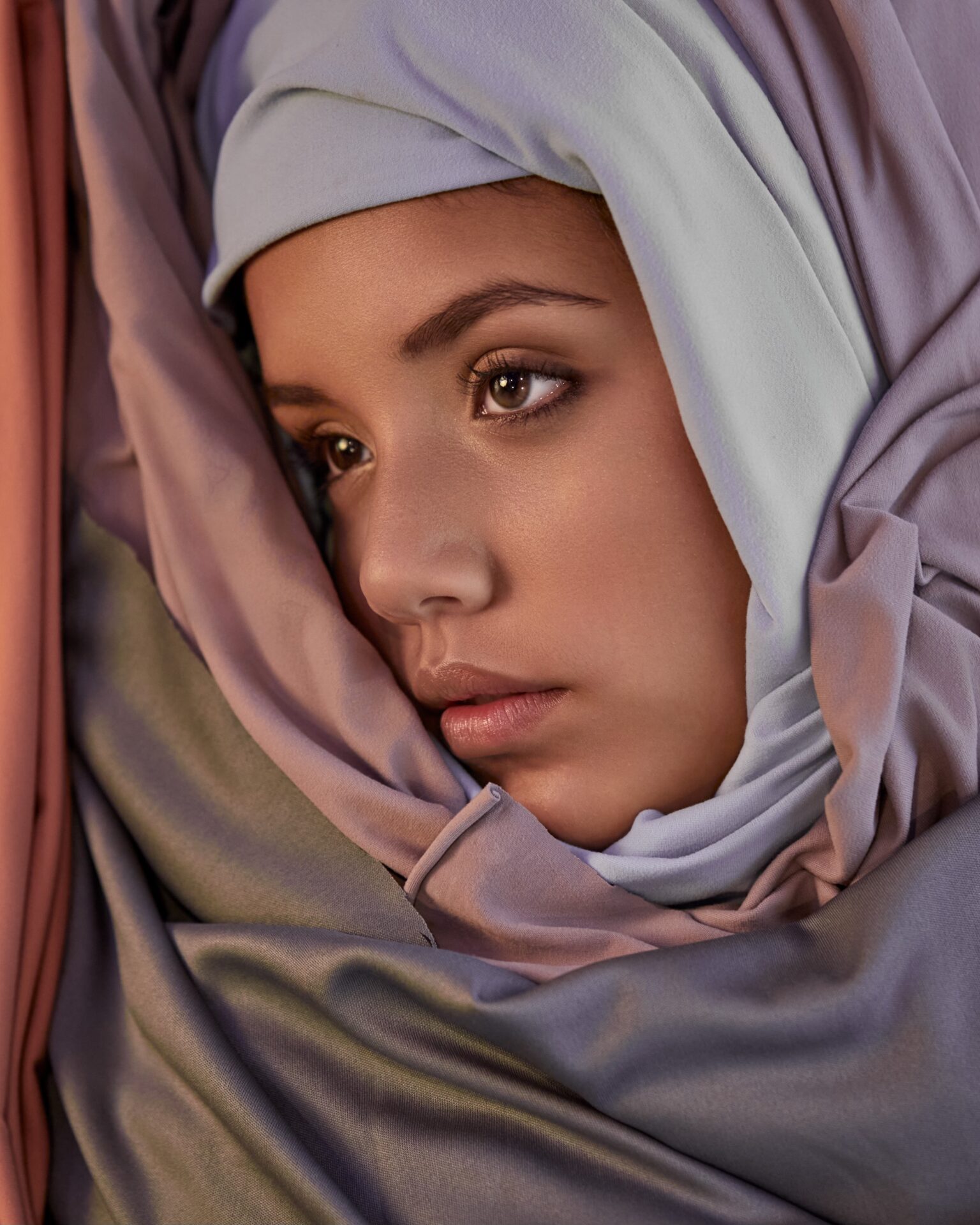 A woman with a head covering on her face.